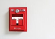 A red fire alarm pull station set on a white wall